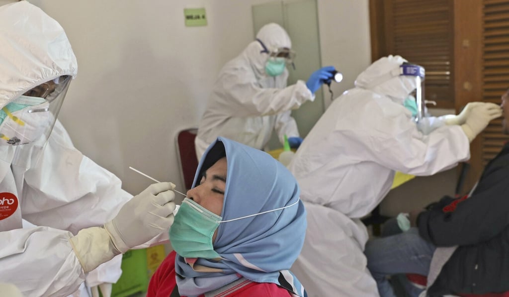 Health workers collects nasal swab samples during a mass test for the new coronavirus in a neighbourhood in Tangerang, Indonesia, on Friday. Photo: AP