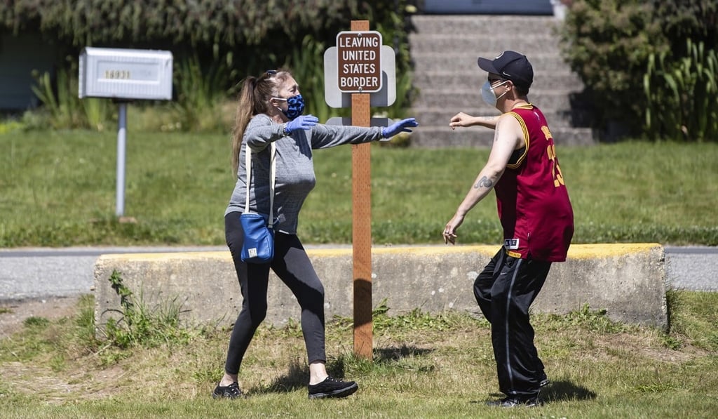 Judy Utgaard (left) of Port Coquitlam, British Columbia, reaches out to hug her daughter Desiree Osborne, of Bellingham, Washington, for the first time in five months, after stepping across the Canada-US border at Peace Arch Historical State Park in July. Photo: The Canadian Press via AP