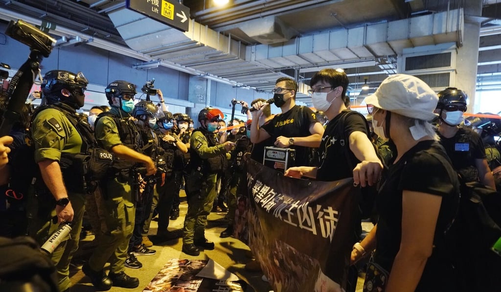 Democratic Party lawmaker Lam Cheuk-ting (centre) at a rally marking the first anniversary of the Yuen Long attack, surrounded by police officers. Photo: Felix Wong Democratic Party lawmaker Lam Cheuk-ting (centre) at a rally marking the first anniversary of the Yuen Long attack, surrounded by police officers. Photo: Felix Wong