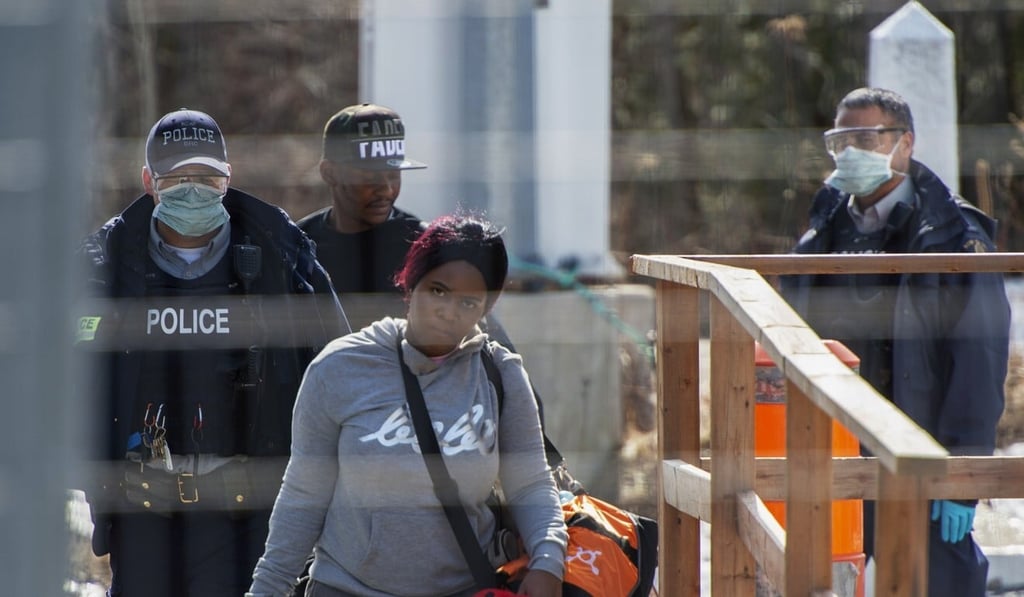 Asylum seekers cross the border from New York into Canada in this file photo from March. Photo: The Canadian Press via AP Asylum seekers cross the border from New York into Canada in this file photo from March. Photo: The Canadian Press via AP