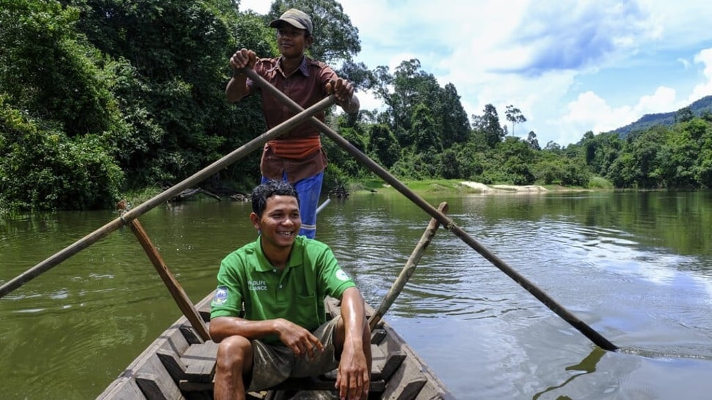 Guide Rin Rith and our boatman as we travel the Areng River. Photo: Peter Ford