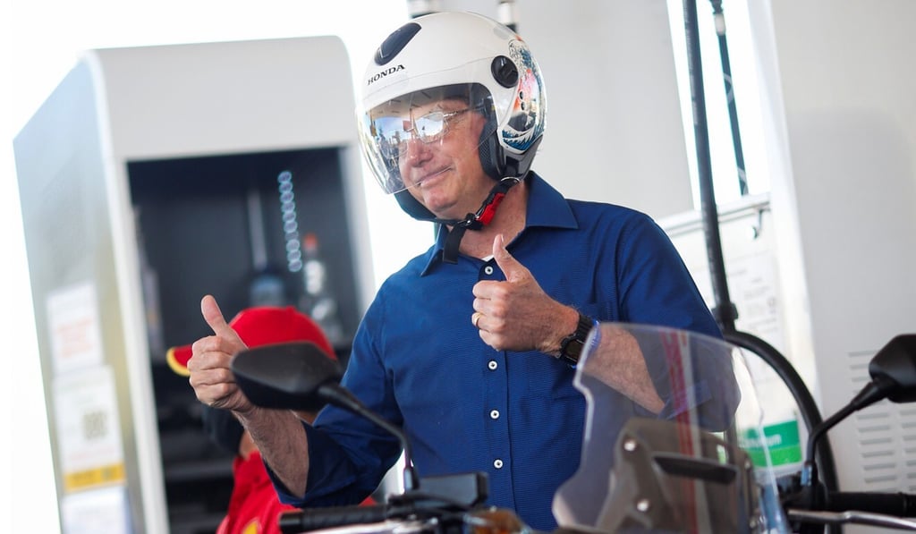 Brazil's President Jair Bolsonaro gestures as he prepares to ride a motorcycle in Brasilia. Photo: Reuters
