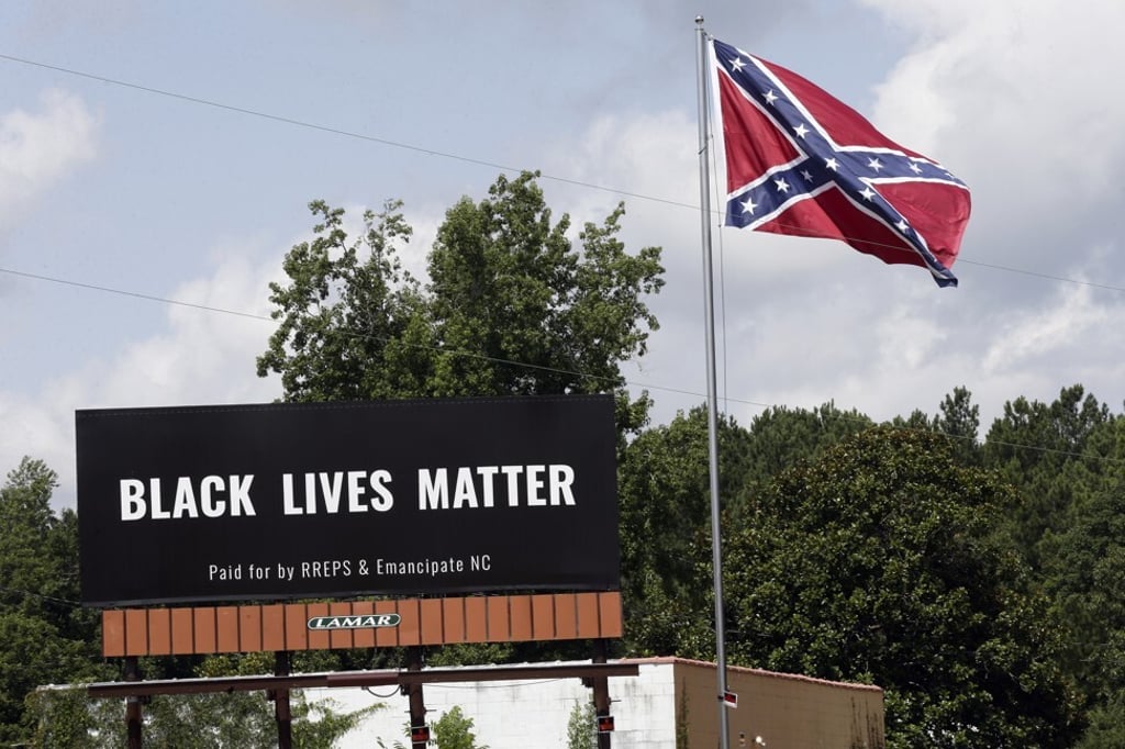 A Black Lives Matter hoarding is seen next to a Confederate flag in Pittsboro, North Carolina, on July 16, 2020. Photo: AP