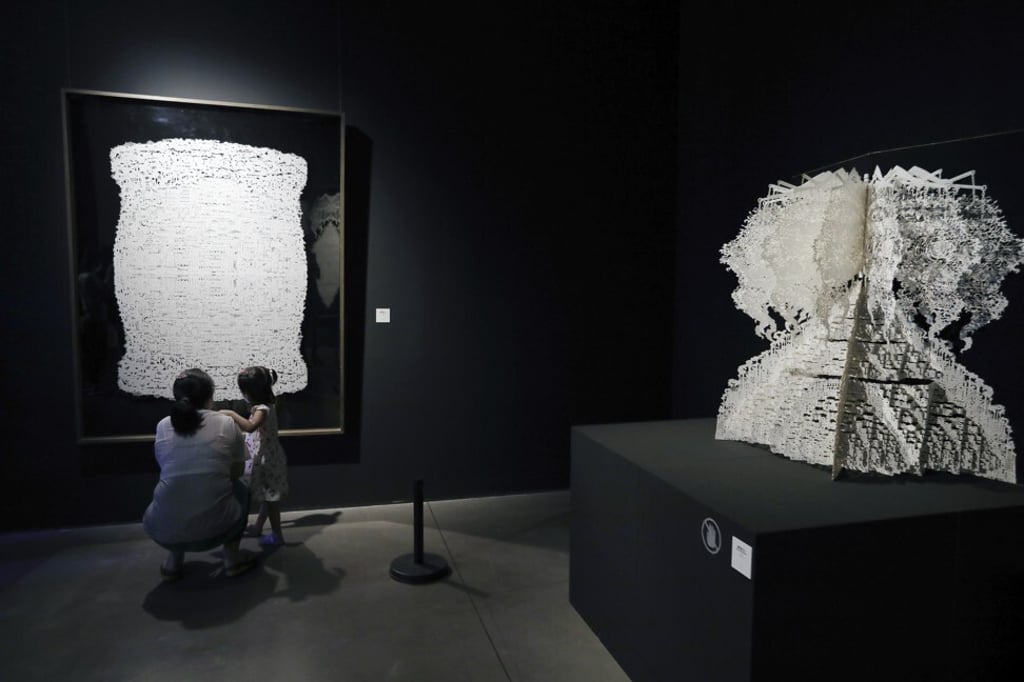 Visitors view paper art at the Today Art Museum’s exhibition. Photo: Simon Song