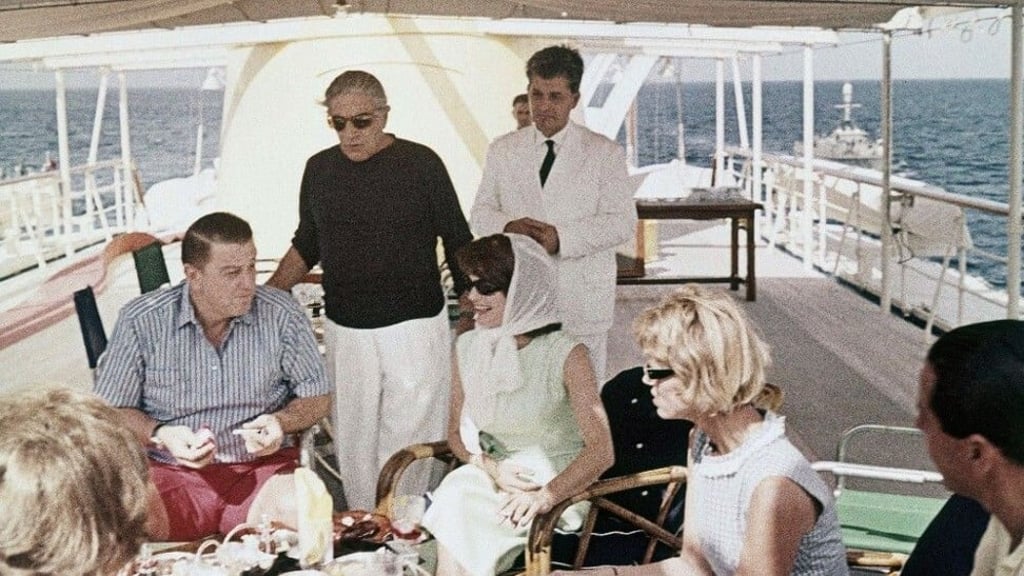 Billionaire Aristotle Onassis stands up to entertain visitors on his yacht. Photo: Luxurylaunches
