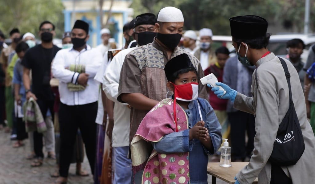 Worshippers line up for temperature check before entering a mosque in Jakarta. Photo: EPA-EFE