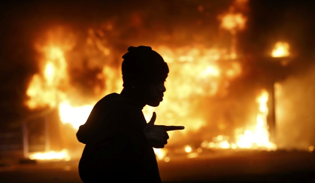 A man walks past a burning building during rioting after a grand jury returned no indictment in the shooting of Michael Brown in Ferguson, Missouri, in November 2014. Photo: Reuters A man walks past a burning building during rioting after a grand jury returned no indictment in the shooting of Michael Brown in Ferguson, Missouri, in November 2014. Photo: Reuters