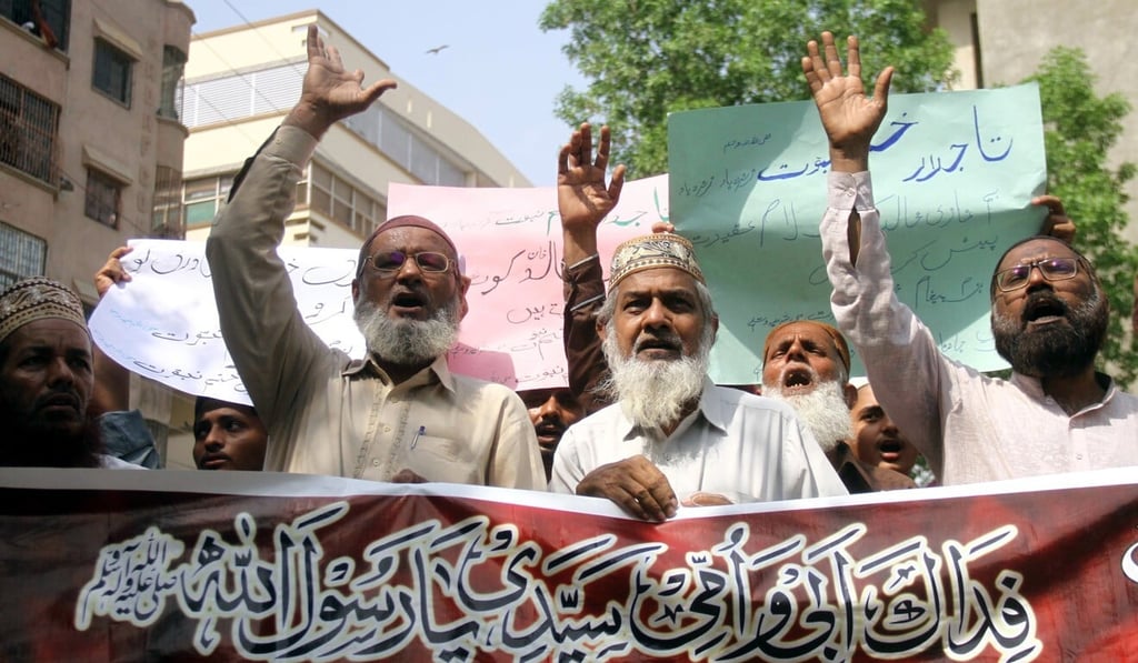 Protesters in Hyderabad, Pakistan on Thursday hold a banner reading in Arabic “I will sacrifice my parents for the Prophet’s honour” in support of the man who killed Tahir Ahmad Nasim Photo: EPA-EFE