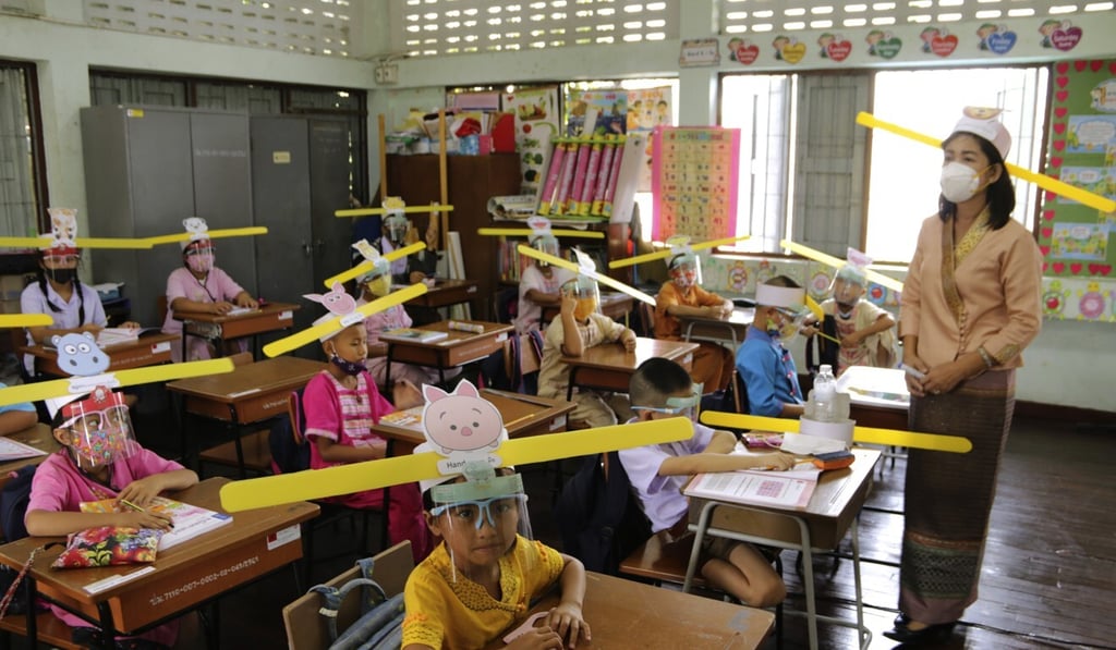 A teacher and students at a school in Chiang Mai wear hats designed to help practice social distancing to curb the spread of coronavirus. Photo: AP A teacher and students at a school in Chiang Mai wear hats designed to help practice social distancing to curb the spread of coronavirus. Photo: AP
