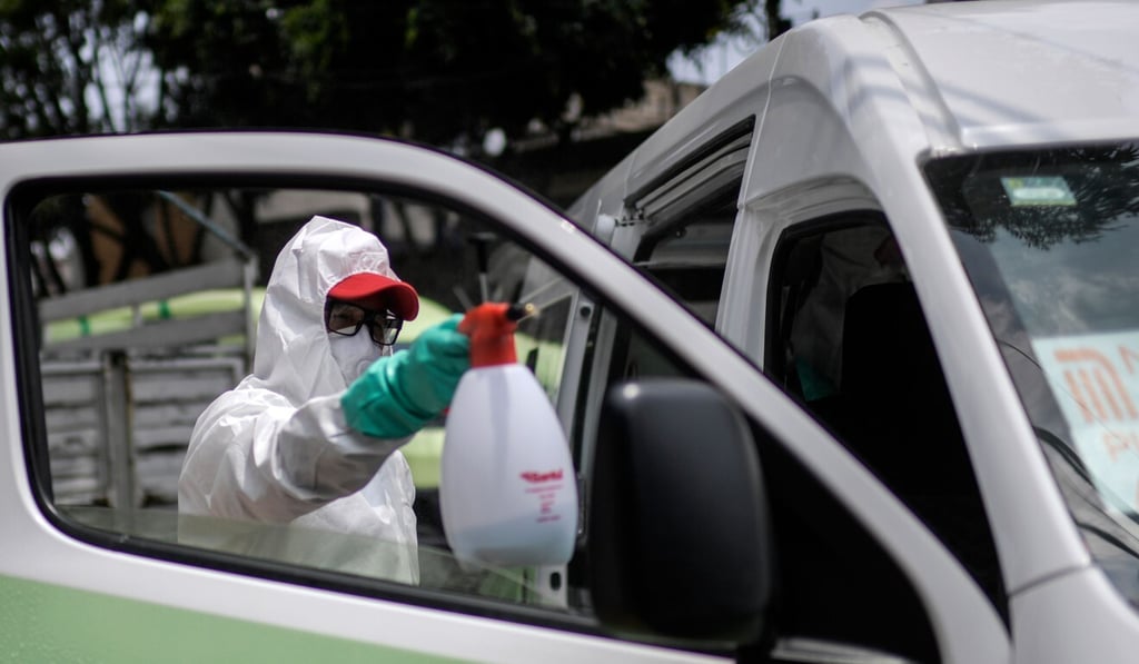 A cleaner wearing personal protective equipment disinfects a public transport van in Mexico City. Photo: AFP A cleaner wearing personal protective equipment disinfects a public transport van in Mexico City. Photo: AFP