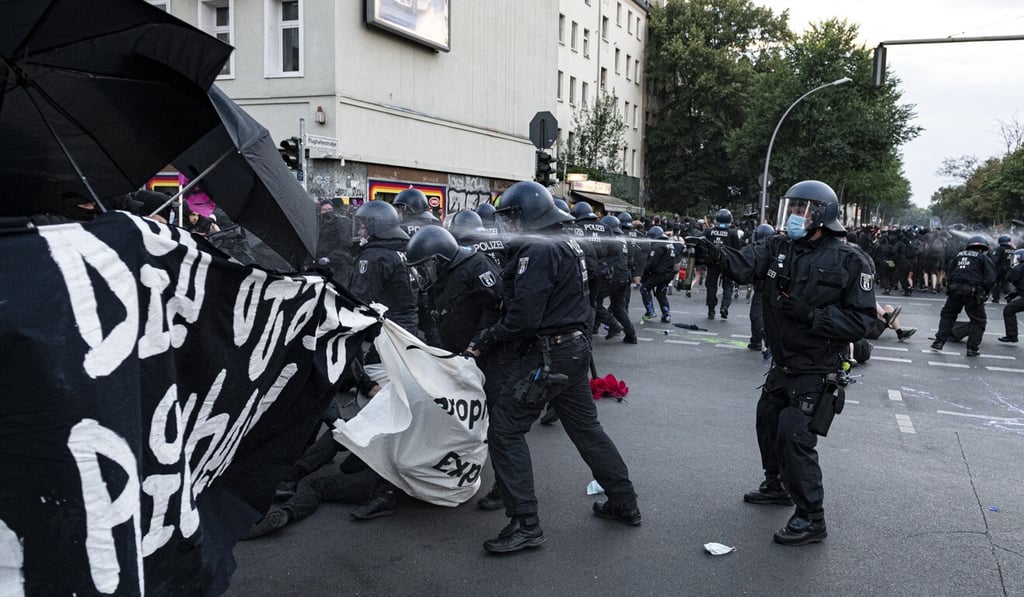 A policeman uses pepper spray to disperse protesters in Berlin’s Schillerkiez neighbourhood. Photo: DPA