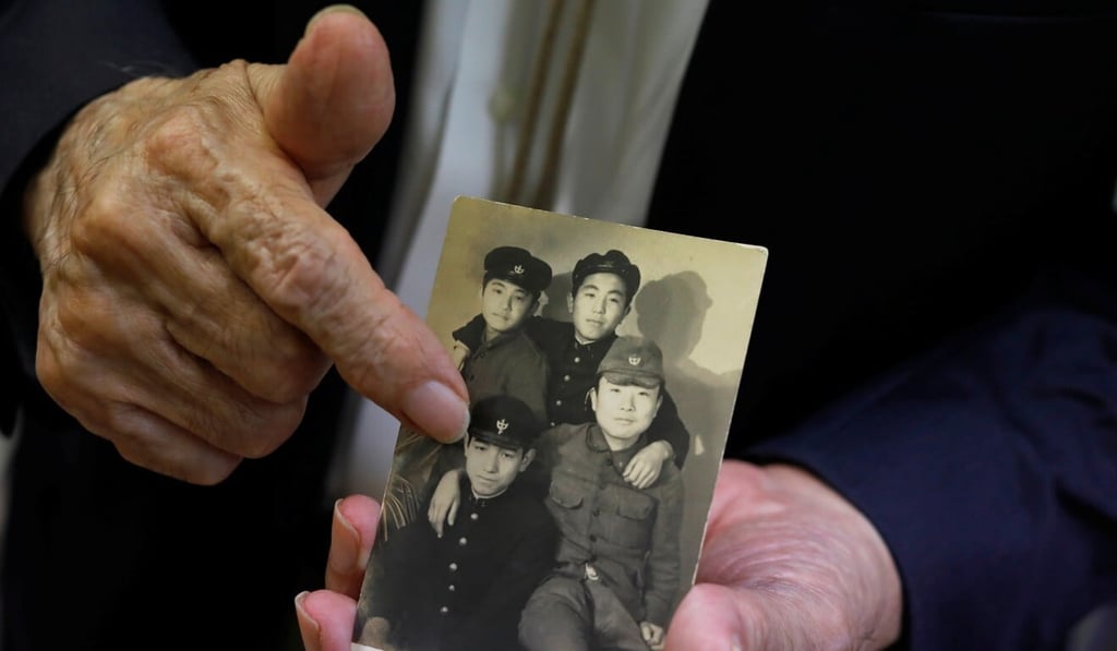 Terumi Tanaka shows a photo of himself with his schoolmates from Nagasaki Junior High School taken in March 1948. Photo: Reuters
