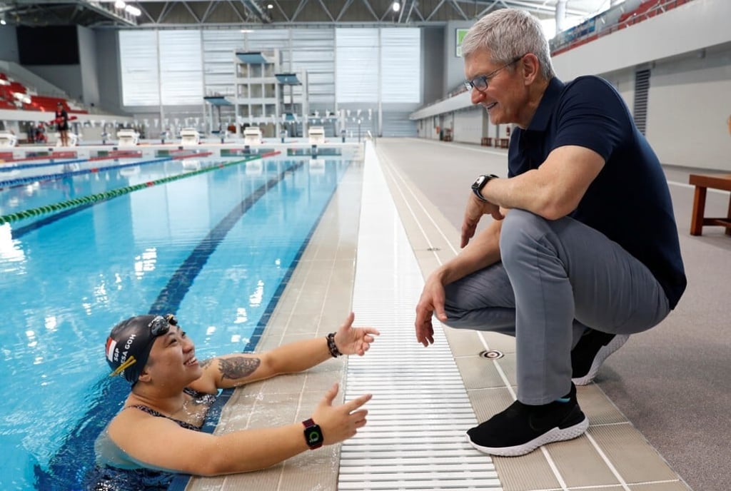 Apple's CEO Tim Cook speaks with Singapore Paralympian Theresa Goh about the Apple Watch she uses for training. Photo: Reuters
