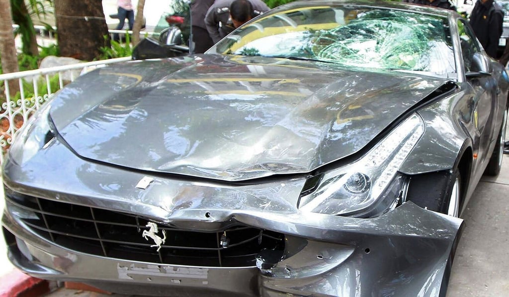Police officers look at the Ferrari involved in the 2012 hit-and-run. Photo: AFP