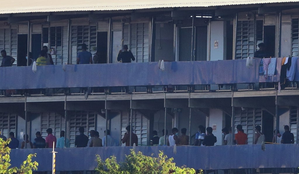 Migrant workers pictured outside their rooms at a dormitory in Singapore that was declared an isolation area in April. Photo: Getty Images