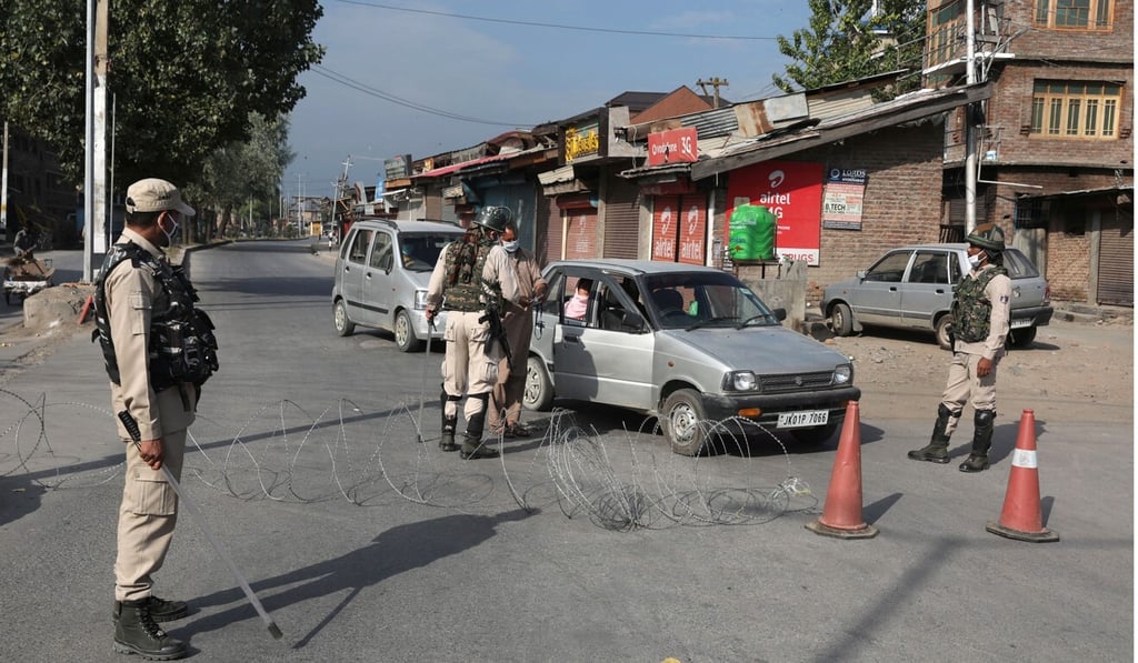 Indian paramilitary soldiers check motorists at a barricade set up during a curfew in Srinagar. Photo: EPA-EFE