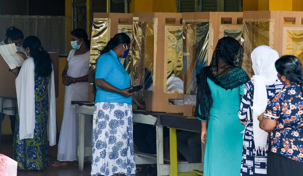 Voters get their fingers inked by electoral officials after casting their ballots in the parliamentary election in Colombo on Friday. Photo: AFP