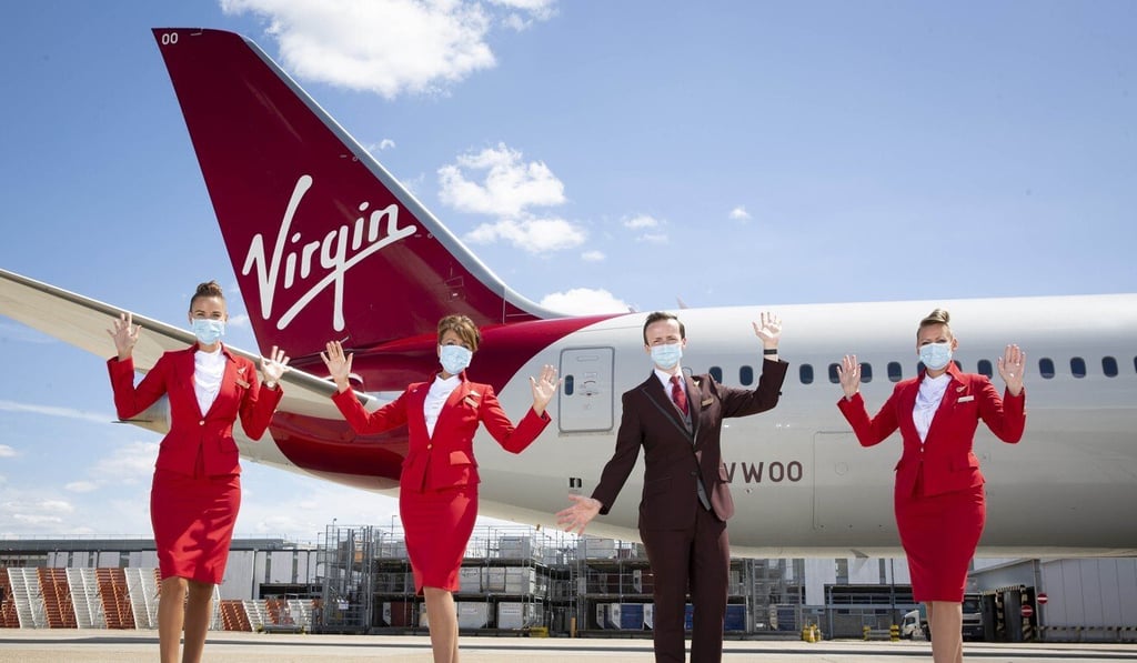 Virgin Atlantic cabin crew members stand in front of a Virgin Atlantic aircraft during the preparation for the first passenger service at Heathrow Airport, after a three month pause due to the Coronavirus. Photo: dpa