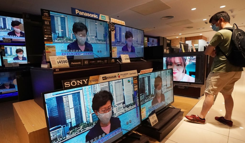 A man watches a live broadcast as Hong Kong Chief Executive Carrie Lam postpones the Legislative Council elections scheduled for September by one year, citing health risks from the Covid-19 crisis. Photo: Felix Wong A man watches a live broadcast as Hong Kong Chief Executive Carrie Lam postpones the Legislative Council elections scheduled for September by one year, citing health risks from the Covid-19 crisis. Photo: Felix Wong