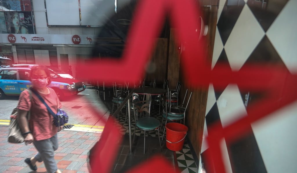 A woman walks past a restaurant in Causeway Bay on Monday. Photo: Nora Tam