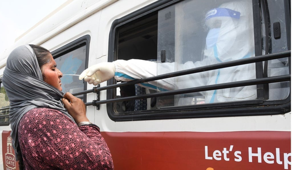 A woman gives swab samples for Covid-19 at a mobile testing clinic in New Delhi. Photo: EPA-EFE A woman gives swab samples for Covid-19 at a mobile testing clinic in New Delhi. Photo: EPA-EFE