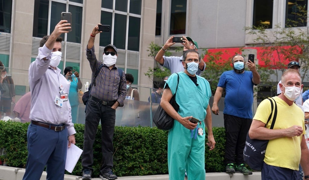 People use their phones to take photos as US President Donald Trump’s motorcade arrives at New York Presbyterian Hospital on Friday. Photo: Reuters