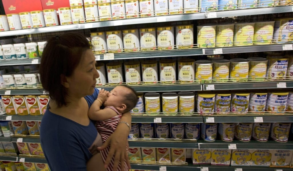 A woman carries a child past powdered milk products at a supermarket in Beijing. Around half of the growth in New Zealand’s milk powder exports over the past decade has come from demand in China. Photo: AP