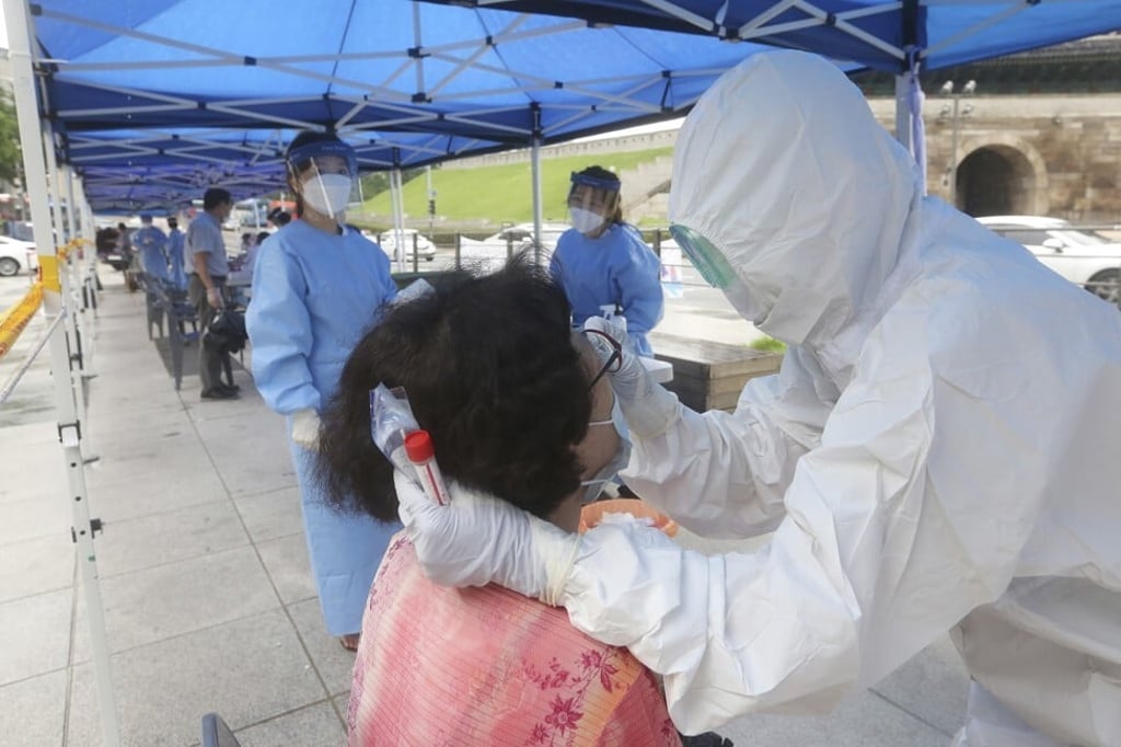 A health worker takes samples from a woman at a makeshift Covid-19 clinic in Seoul on August 10, 2020. Photo: AP A health worker takes samples from a woman at a makeshift Covid-19 clinic in Seoul on August 10, 2020. Photo: AP