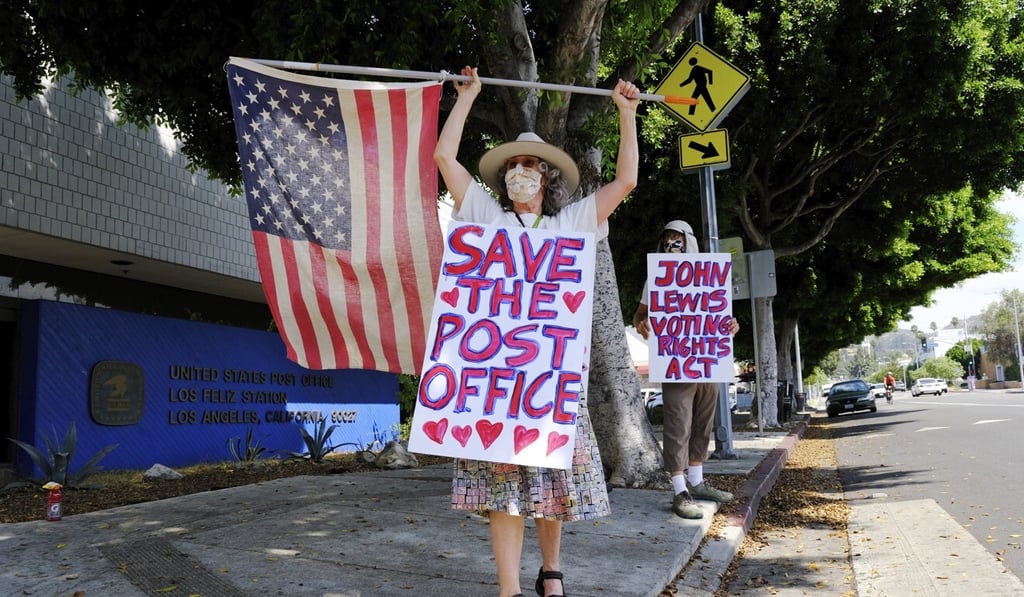 Erica Koesler, left, and David Haerle, both of Los Angeles, demonstrate outside a USPS post office in the Los Feliz section of Los Angeles. Photo: AP Photo