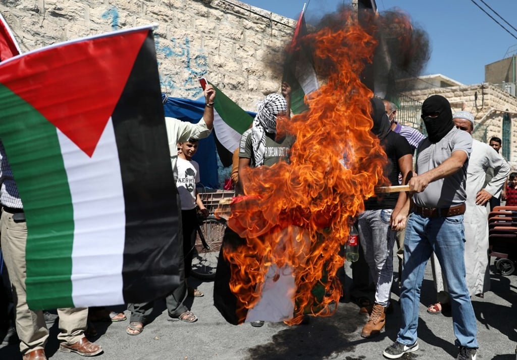 Palestinian protesters burn the flag of the United Arab Emirates in a protest against the Gulf state’s agreement to establish diplomatic ties with Israel. Photo: EPA Palestinian protesters burn the flag of the United Arab Emirates in a protest against the Gulf state’s agreement to establish diplomatic ties with Israel. Photo: EPA