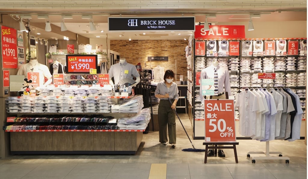 A worker mops the floor of a retail store in a quiet shopping centre in Tokyo. Photo: AP