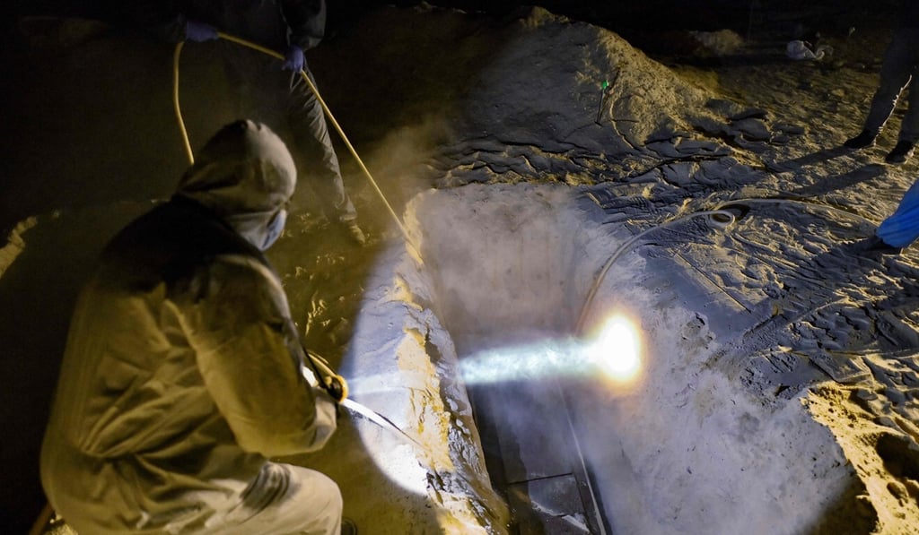 Funerary workers bury a coffin in a massive burial ground for low income people and unidentified victims of Covid-19 in southern Peru. Photo: AFP