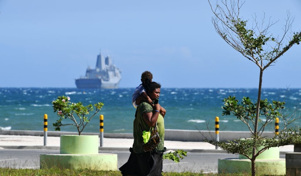 A Papuan villager carrying a child in Port Moresby. Photo: AFP A Papuan villager carrying a child in Port Moresby. Photo: AFP