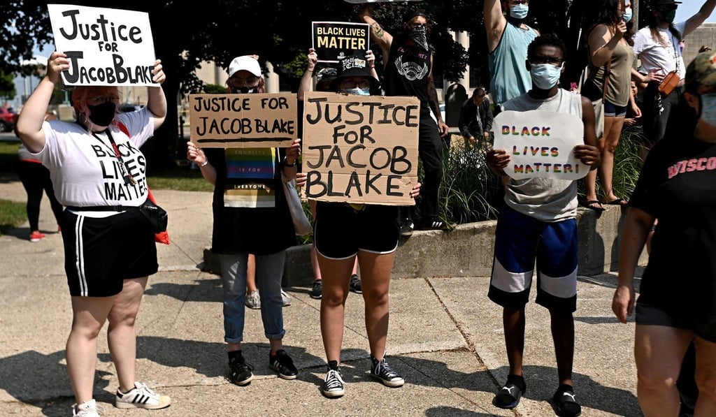 People hold placards as they gather for a protest after the shooting of Jacob Blake. Photo: Reuters