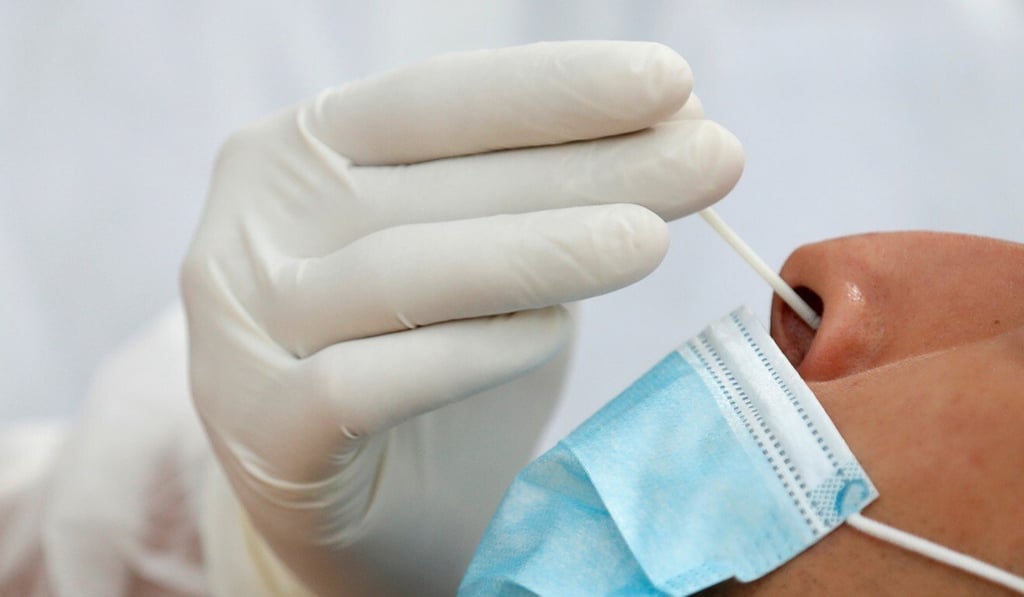A health worker administers a Covid-19 nasal swab test. One source of confusion has been the type of swab test that different governments require. Photo: Reuters A health worker administers a Covid-19 nasal swab test. One source of confusion has been the type of swab test that different governments require. Photo: Reuters