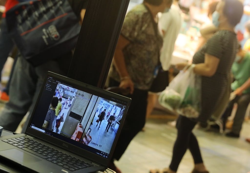 A monitor checks the temperature of customers outside Yeung Uk Road Market in Tsuen Wan, Hong Kong, which was closed early on August 11 to allow deep cleaning and disinfection to be carried out after a preliminary confirmed case of the coronavirus disease, Covid-19, was found to be related to the market. Photo: K.Y. Cheng