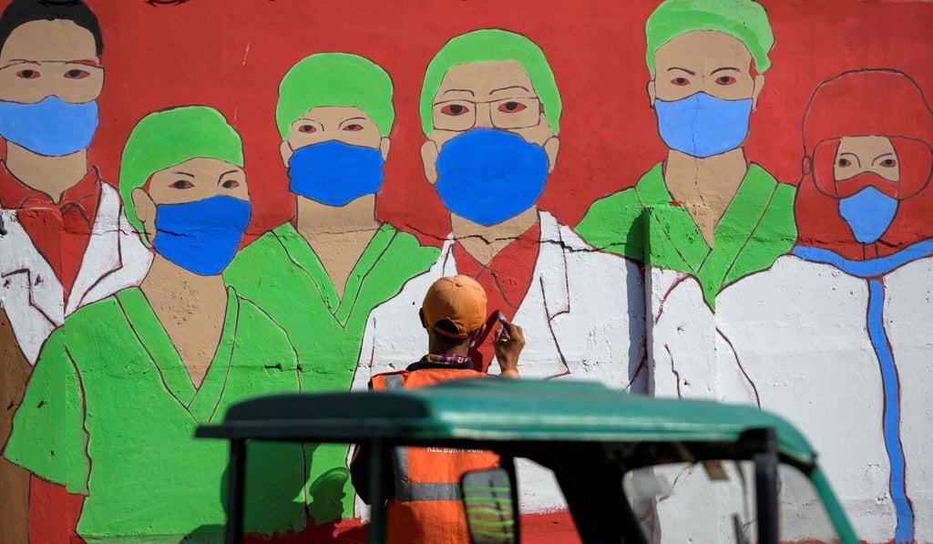 A city worker draws a mural about the coronavirus pandemic on a wall in Jakarta. Photo: AFP A city worker draws a mural about the coronavirus pandemic on a wall in Jakarta. Photo: AFP