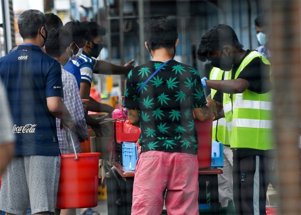 Migrant workers queue to receive food at the Tuas South dormitory in Singapore after it was placed under government lockdown to prevent the spread of coronavirus. Photo: AFP
