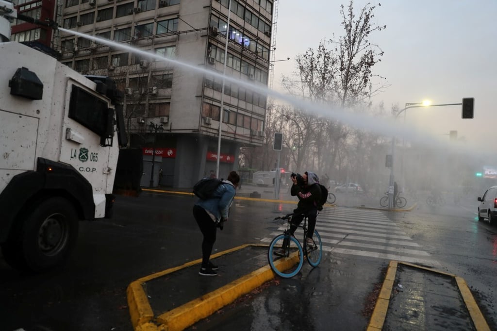 Riot police in Chile deploy a water cannon to break up a protest against the government on August 28. Waves of social unrest have hit middle-income countries since last year. Even in better-performing economies, like Chile, many feel that their expectations and aspirations have not been met. Photo: Reuters