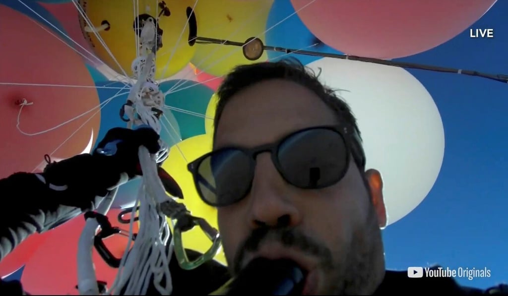 A screenshot shows performer David Blaine using a parachute under a cluster of balloons during a stunt in Arizona on Wednesday. Photo: David Blaine handout via Reuters