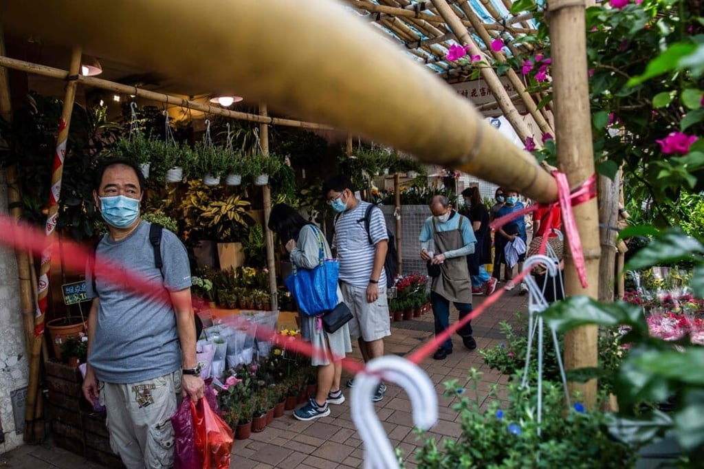 People walk through a flower market in Hong Kong on August 16. Double-digit inflation is a thing of the past, according to the data. But does anyone believe their costs rise by just 4 per cent a year? Photo: AFP