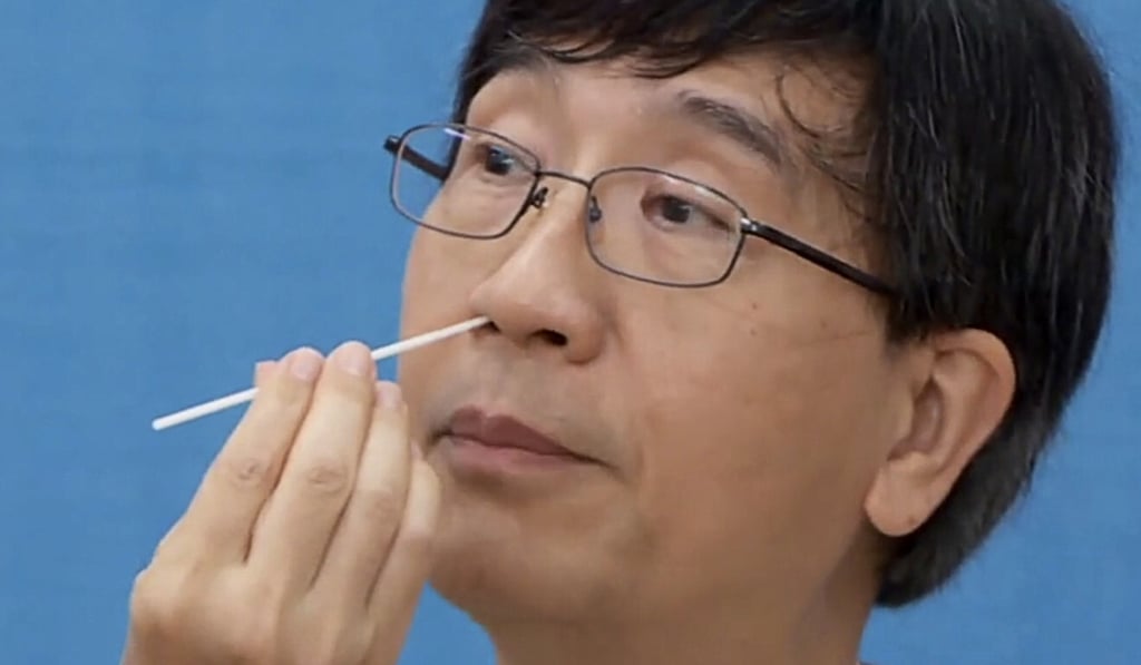 Professor Yuen Kwok-yung, who says just a handful of cases could undermine Hong Kong, has a nasal sample taken. Photo: Cable TV News