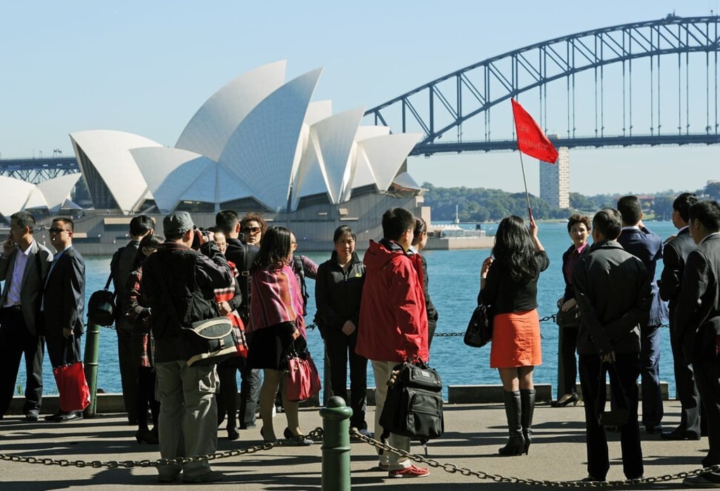 Chinese tourists take photos in front of the Sydney Opera House and Harbour Bridge. Photo: AFP/GettyImages