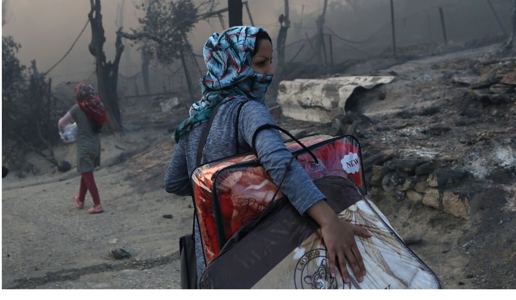 A migrant carries her belongings following a fire at the Moria camp for refugees and migrants on the island of Lesbos. Photo: Reuters