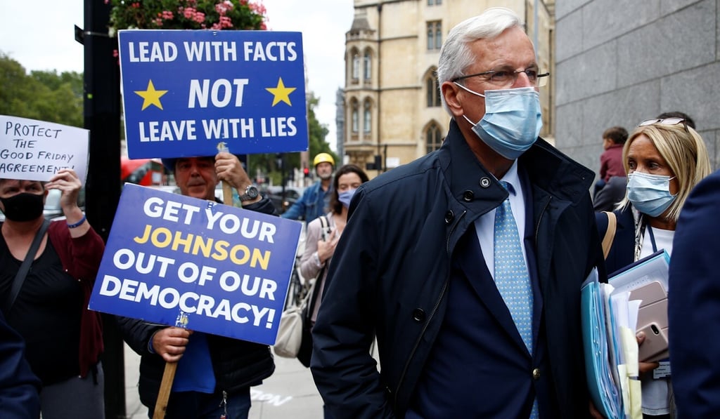 Anti-Brexit demonstrator Steve Bray holds placards as EU Chief Negotiator Michel Barnier walks with an entourage to a meeting in Westminster, London on Wednesday. Photo: Reuters