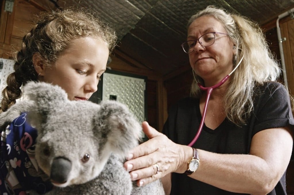 Izzy Bee (left) and her mother Ali look after a koala bear in Izzy’s Koala World. Photo: AP Izzy Bee (left) and her mother Ali look after a koala bear in Izzy’s Koala World. Photo: AP