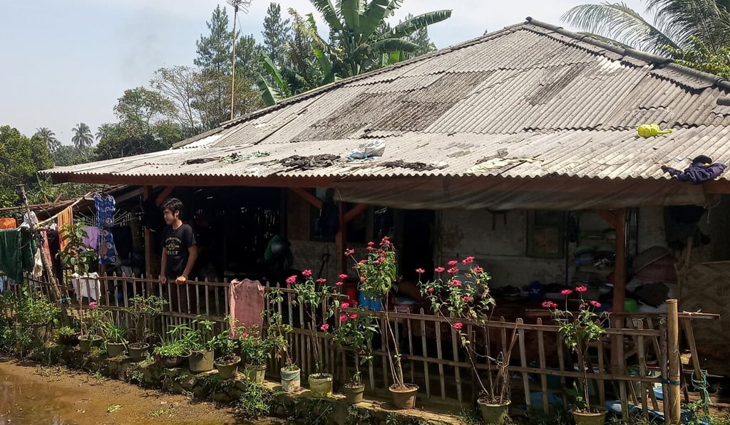 Ari Harifin, 23, stands outside his family's house in Sukabumi, West Java. Neighbours barricaded the lane leading to the house after his mother tested positive for Covid-19. “I was angry of course,” he said, having tested negative and self-isolated at home. Photo: Reuters