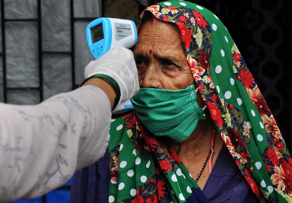 A health worker checks temperature of a woman at the Sathe Nagar slum in Mumbai. Photo: ZUMA Wire/dpa