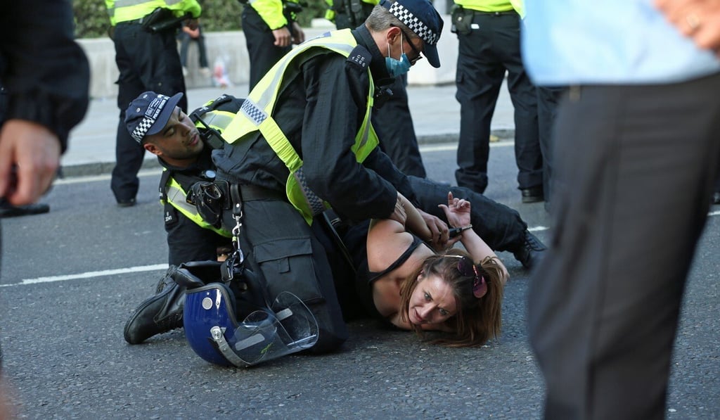 Police officers detain a woman during an anti-vaccine protest in Trafalgar Square. Photo: PA Wire via dpa Police officers detain a woman during an anti-vaccine protest in Trafalgar Square. Photo: PA Wire via dpa