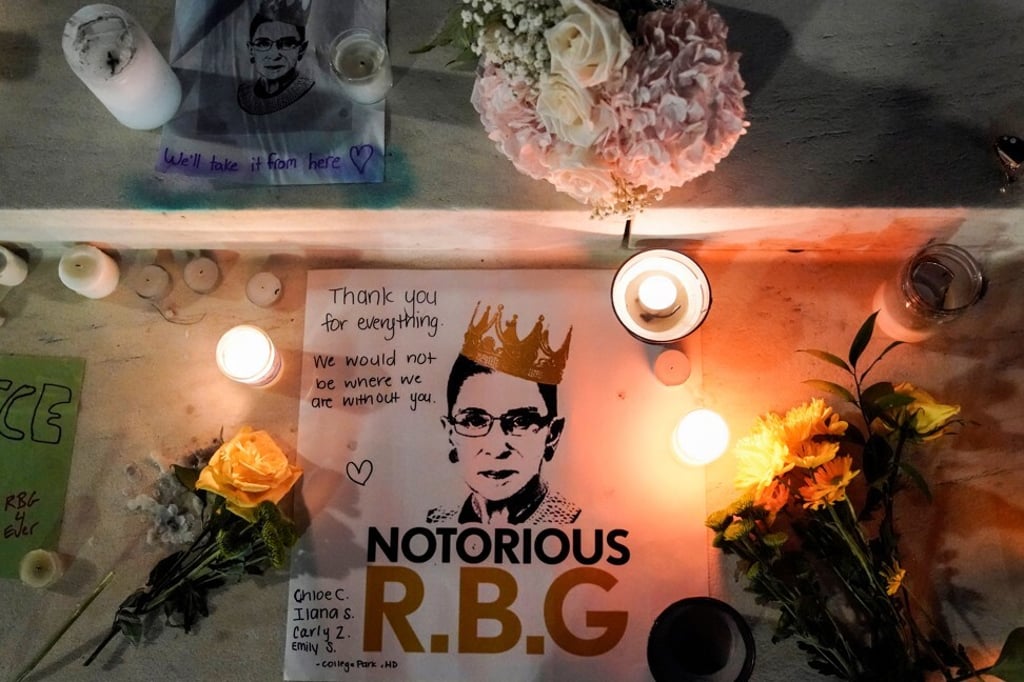Candles are lit next to pictures of Ruth Bader Ginsburg, as people mourn her death, at the Supreme Court in Washington on September 19. Photo: Reuters
